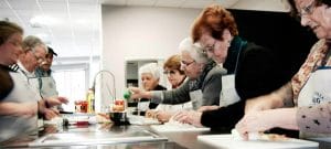Personas mayores cocinando en taller de Cocinoterapia en Kitchen in Poio