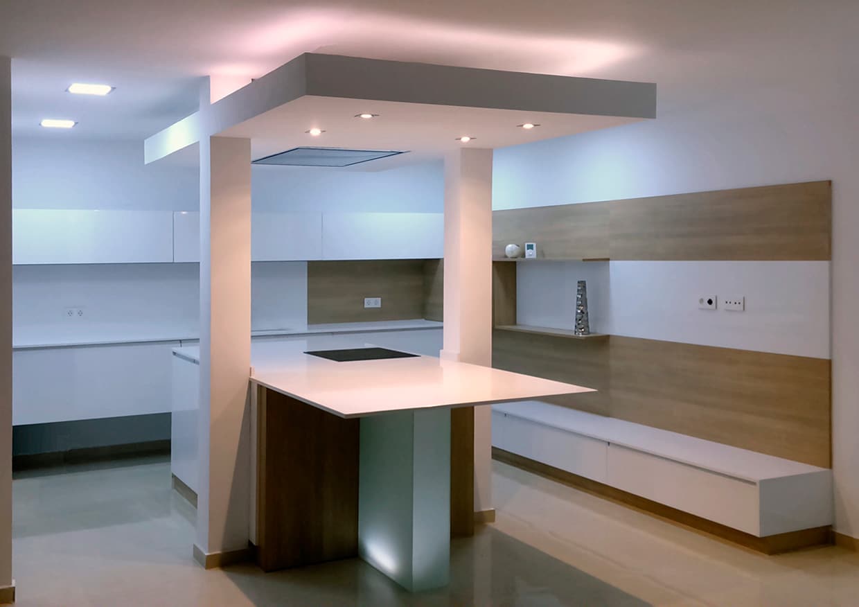 cocina moderna blanca con isla y campaña integrada en techo