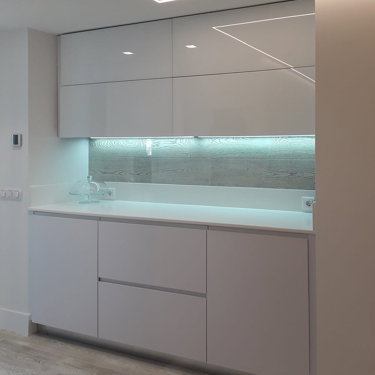 Muebles de cocina en blanco brillo con iluminación inferior