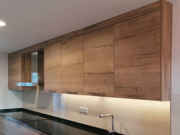 Detalle de muebles altos Detalle de muebles altos con LED inferios en una cocina clasica en madera con tirador