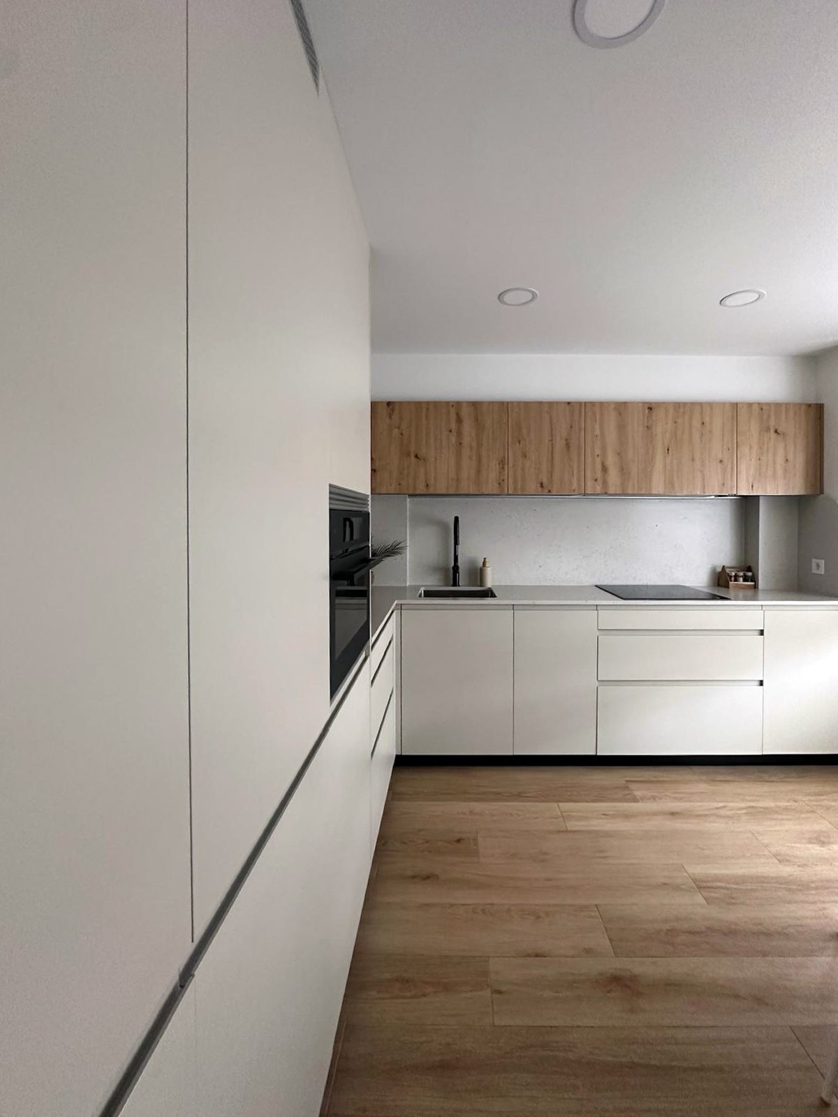 Columnas altas en Beige Oliva y muebles altos en Roble Dorado en una cocina Senssia Fussion con suelo de madera