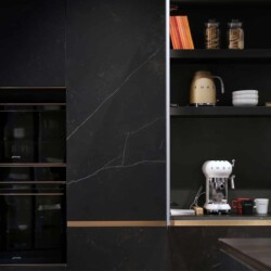 Composición de muebles columna modelo FUSSION acabado cerámica KELYA con pequeños electrodomésticos en el interior Composición de muebles columna en acabado cerámica con mueble abierto que contiene pequeños electrodomésticos de cocina y otros elementos.