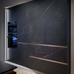 Composición de Muebles Columna en Perspectiva | Modelo FUSSION de Senssia en Kitchen in Salamanca Vista lateral de composición de mobiliario columna en aluminio y acabado cerámica con puertas cerradas y electrodomésticos integrados