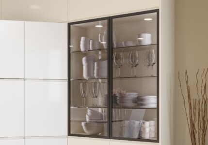 Mueble vitrina con puertas de cristal con copas y vajilla en su interior