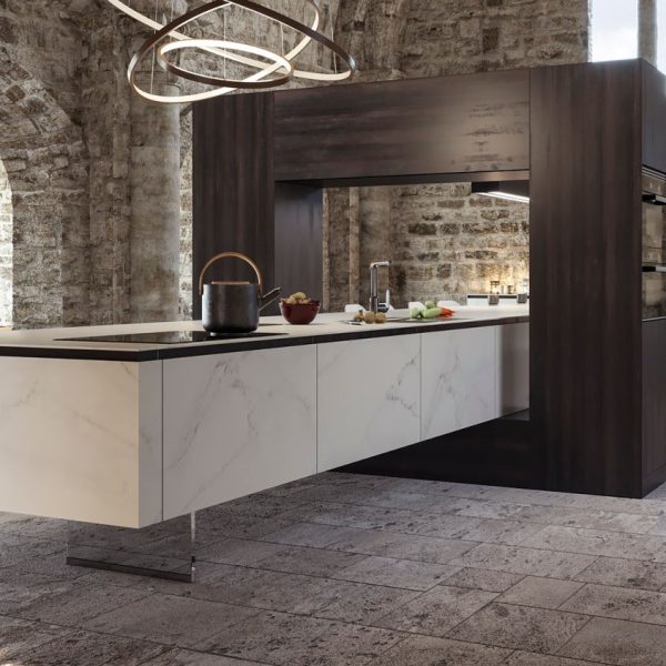 Cocina moderna con muebles bajos e isla tipo mármol blanco y muebles altos en madera oscura en estancia de piedra