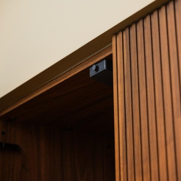 Detalle de sistema push electrónico en una puerta modelo Coral de madera natural Nogal, sin tirador, en una cocina de la exposición de Kitchen in Santiago.