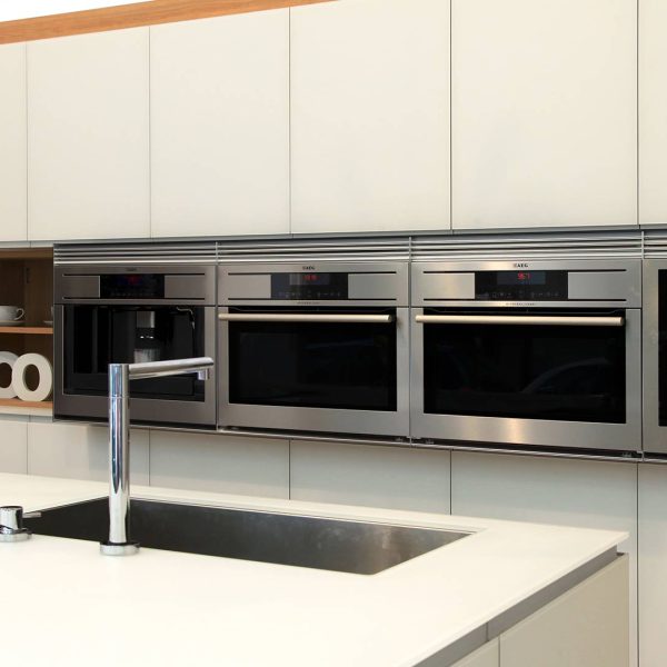 Frente de electrodomésticos situados en muebles columna en color blanco de cocina en tienda Kitchen in Vigo