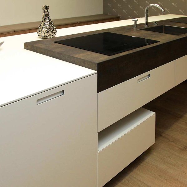 Isla de una cocina moderna color blanco y cerámica, con dos placas y fregadero en la tienda Kitchen in Vigo